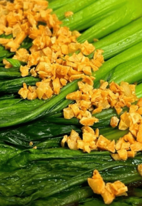 Bok choy topped with oyster sauce and crispy garlic